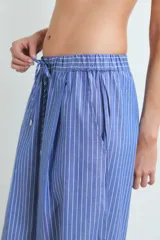 Pantalón ancho de algodón, color azul con rayas verticales blancas, tiro alto con cordón ajustable y pliegues frontales.
