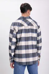 Sobrecamisa de franela a cuadros azul marino, gris y blanco, con cuello clásico, cierre frontal con botones, dos bolsillos de parche en el pecho y mangas largas con puños abotonados.