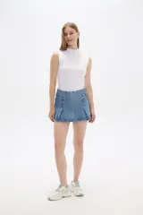 Minifalda de jean azul con cintura ancha y pliegues frontales.