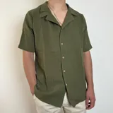 Camisa verde militar de muselina con manga corta, cuello solapa y corte oversize.