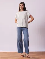 Blusa de lino color blanco con rayas verticales, de la marca Cable & Gauge. Tiene hombros con aplique de botones.
