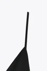 Vestido largo negro de tejido crepe, con escote en V pronunciado y tirantes finos ajustables. Presenta aberturas laterales en el bajo.