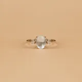 Anillo solitario de oro amarillo 18k con aguamarina central ovalada y brillantes laterales.