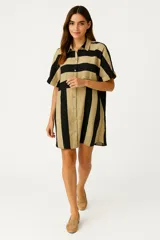 Vestido camisero corto a rayas verticales negras y beige, con cuello camisero, mangas cortas y cierre frontal con botones.