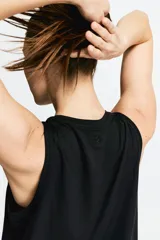 Musculosa deportiva corta color negro, de corte holgado, con cuello redondo y sisas amplias. Confeccionada en tejido funcional DryMove™ que ayuda a absorber el sudor.