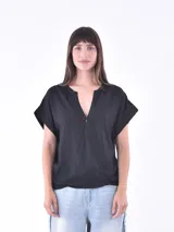 Blusa negra con escote en V, manga corta y corte asimétrico.