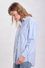 Camisa celeste con rayas verticales blancas, de corte oversize y manga larga.