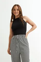 Musculosa negra corta, de algodón y lycra, con cuello alto y sisas anchas.