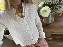 Gargantilla con tira de cuero sintético marrón y dije dorado con forma de sol.