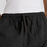 Pantalón cargo de tejido ligero de nylon reciclado, color negro con efecto arrugado. Presenta cintura ajustable con cordón de sarga y dobladillo a presión para ajustar la silueta.