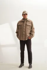 Camisa estilo leñadora color beige, confeccionada en lana fina. Presenta cuello clásico, abrochadura frontal a la vista, mangas largas con puños abotonados y dos bolsillos plaqué con tapa abotonada en el pecho.