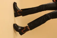 Bota corta color camel de cuero sintético, con detalle de pespuntes negros en el tobillo y cierre lateral con cremallera.