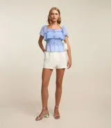Blusa peplum de chiffon celeste con lunares blancos, escote cuadrado con lazo, mangas cortas godê, lastex en la espalda y pedrería de strass aplicada.