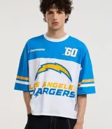 Remera boxy de algodón celeste y blanco con estampa del logo y nombre del equipo de fútbol americano Los Angeles Chargers.