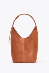 Bolso tipo saca color marrón de piel, con asa al hombro y cierre imantado. Incluye cartera interior con cierre de cremallera metálica.