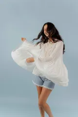 Camisa azul de algodón con cuello alto y mangas largas acampanadas con detalles de puntilla.