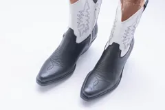 Bota texana de cuero negro con bordados en el lateral y taco bajo.