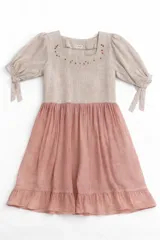 Vestido a la rodilla blanco y rosado, con bordado floral en el escote, mangas 3/4 con lazo y falda fruncida.