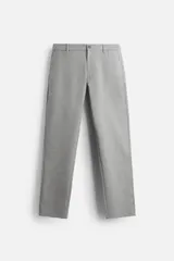 Pantalón gris de corte slim fit confeccionado en tejido elástico. Cuenta con cintura elástica, bolsillos frontales y traseros de vivo. Cierre frontal con cremallera y botón.