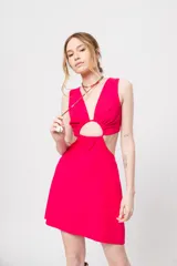 Vestido corto fucsia con escote en V y corte a la cintura. Presenta aberturas laterales y lazo ajustable en la espalda.