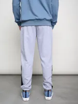 Pantalón de jogging negro con puños ajustados, cortes laterales y cambio de color en la parte inferior de la pierna.