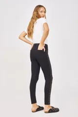 Pantalón de jean negro de corte slim, con tiro alto y detalles de strass plateados en los laterales.