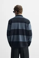 Polo relaxed fit de punto tejido en hilatura de algodón. Cuello solapa con cierre frontal de botonadura. Manga larga. Acabados en rib.