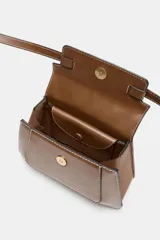 Bolso de mano tipo satchel color marrón, con costuras contrastantes en blanco. Presenta un asa superior curva, solapa frontal con dos hebillas metálicas decorativas y correa ajustable para llevar al hombro.