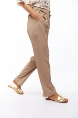 Pantalón de vestir negro de corte recto, con bolsillos laterales y presillas con hebillas decorativas en la cintura.