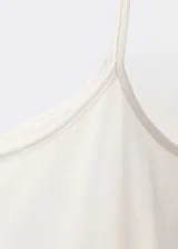 Top blanco de seda con tirantes finos y cuello redondo.