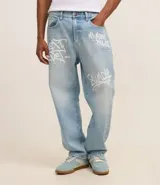 Pantalón baggy de jeans celeste con estampa de letras estilo grafiti en blanco.