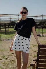 Minifalda pareo blanca con estampado de lunares negros y lazo lateral.