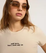 Blusa new t-shirt de manga corta color beige, confeccionada en algodón bci, con cuello redondo y estampado frontal con la frase "Self Love, But I Text My Ex".