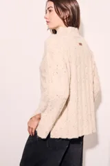 Polera de punto texturada en color beige melange, con calce oversize y cuello alto.