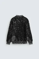 Sweater negro con cuello redondo y manga larga, tejido con diseño geométrico jacquard en blanco.