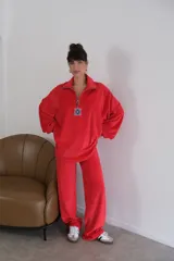 Buzo rojo de plush terciopelo con cierre parcial frontal y detalle de etiqueta con logo en el pecho.