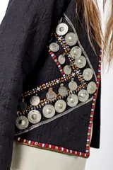 Saco corto negro con bordados y apliques de monedas plateadas.