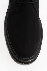 Botas safari de gamuza negra, estilo chukka, con cordones finos y suela de goma negra gruesa y dentada.