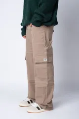 Pantalón cargo negro de corte relaxed fit y tiro medio, con múltiples bolsillos y costuras a contraste en color blanco.