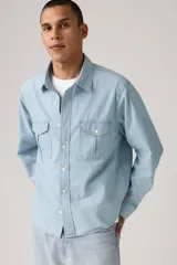 Camisa celeste de jean con dos bolsillos frontales con solapa y cierre de botón.