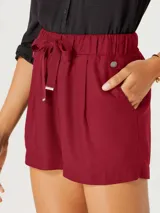 Short de tela color rojo con cintura elastizada, lazo ajustable y bolsillos laterales.