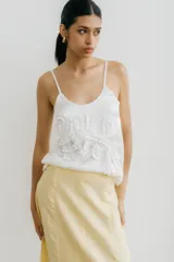 Musculosa blanca de tirantes finos, escote redondo y diseño con tela fruncida en la parte delantera.