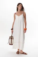 Vestido largo color crudo con breteles finos y costuras a la vista en color azul.