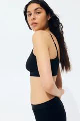 Bralette negro sin costuras, con breteles finos ajustables y banda inferior acanalada. Copas forradas con relleno extraíble.