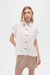 Camisa blanca de algodón con cuello clásico, manga corta con botón y cierre frontal con botones de carey.