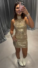 Vestido dorado de lentejuelas, corto y al cuerpo, con cuello halter.