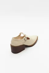 Zapato tipo T-bar de charol negro con hebilla lateral y taco ancho.