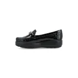 Mocasín de cuero charol negro con plataforma blanca y detalle de hebilla metálica plateada en el empeine.
