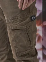 Pantalón de corte ajustado en gris oscuro, con múltiples bolsillos y diseño moderno.