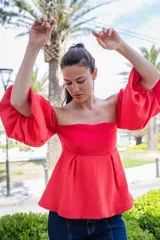 Blusa blanca strapless con mangas largas abullonadas.